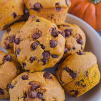 A pile of pumpkin chocolate chip muffins in a bowl.