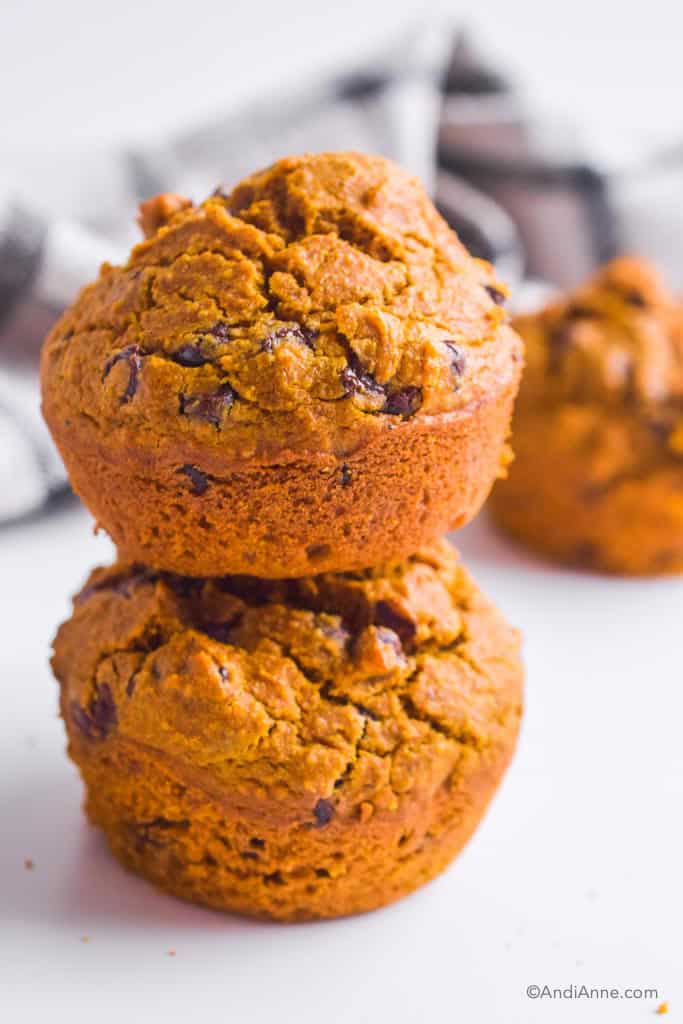 two stacked pumpkin chocolate chip muffins.