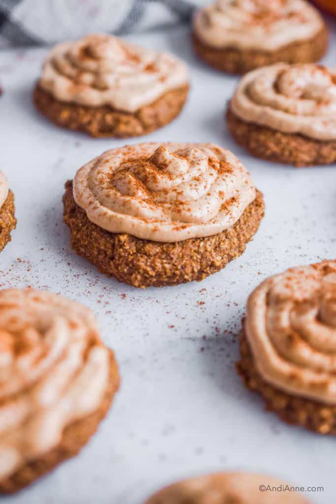 Side angle of pumpkin oatmeal cookies with cream cheese frosting and cinnamon sprinkled on top