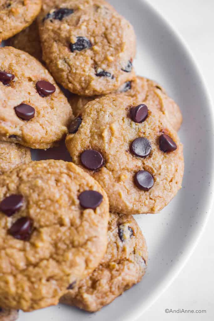 close up of cookies on a white plate piled together.