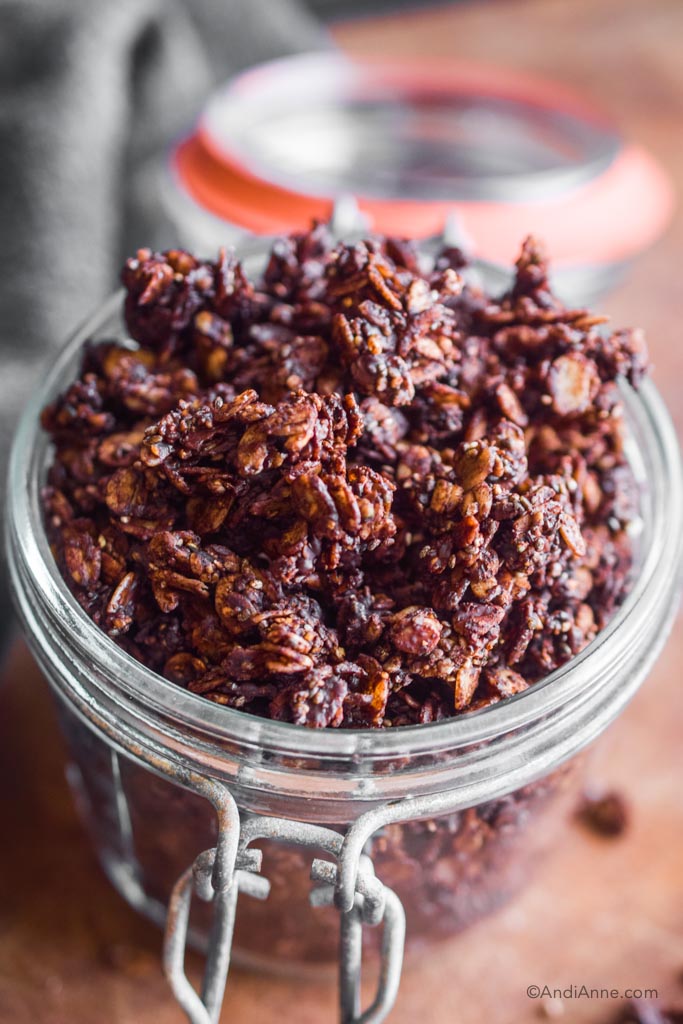 close up of chocolate granola clusters in a glass jar