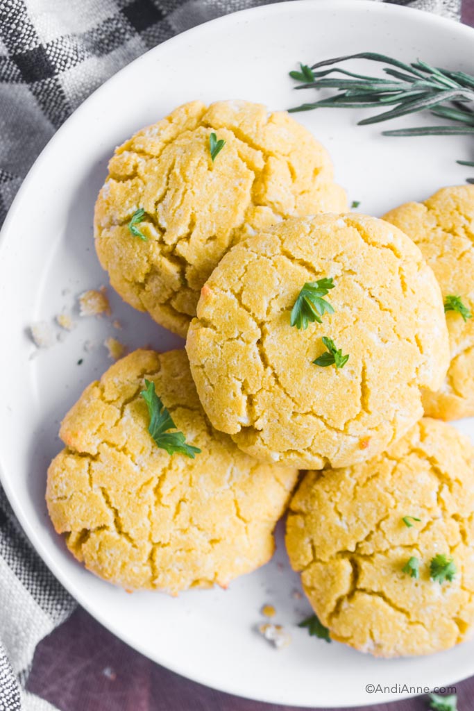 coconut flour biscuits with bits of parsley stacked on a white plate
