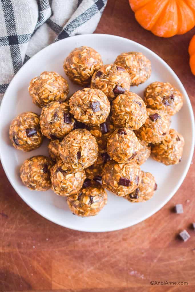 looking down at a white plate with pumpkin oat energy balls on it.