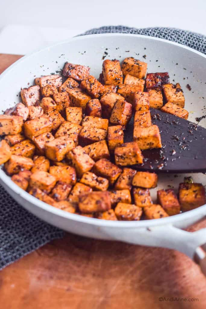 cooked basil balsamic tofu in a frying pan with wood spatula
