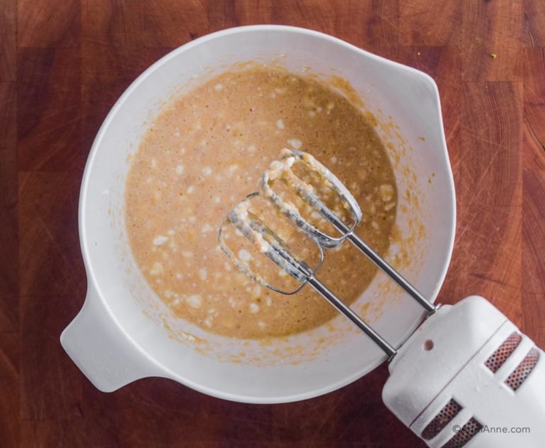 wet ingredients in white bowl with hand mixer