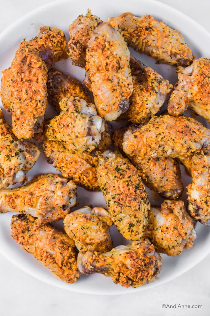 close up of parmesan chicken wings piled in a white dish
