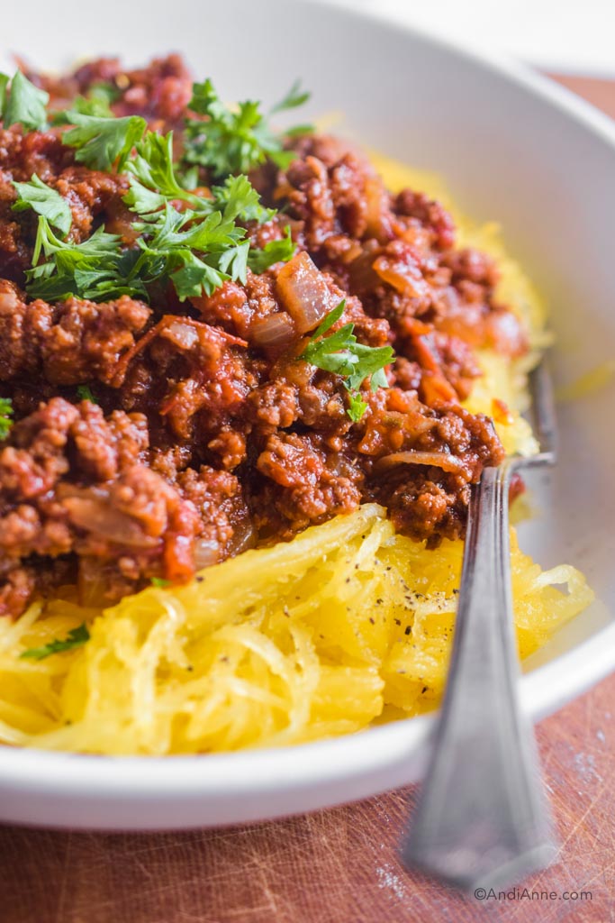 spaghetti squash bolognese close up detail with parsley and a fork. 