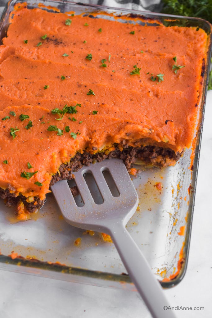Sweet potato shepherds pie with corner cut out and spatula in the dish.