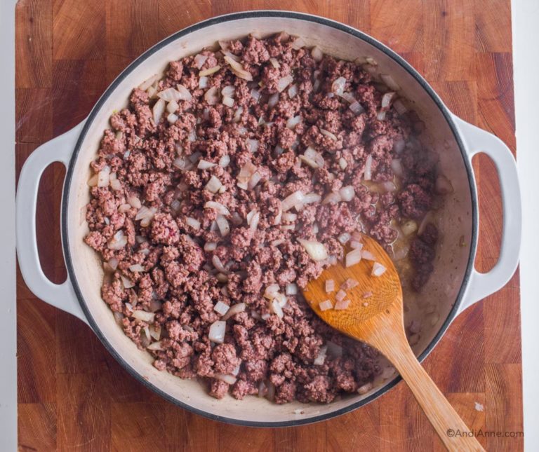 cooked ground beef and onion in a pan with wood spatula