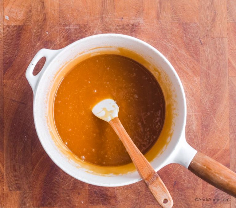melted caramel sauce in white pot with small spatula