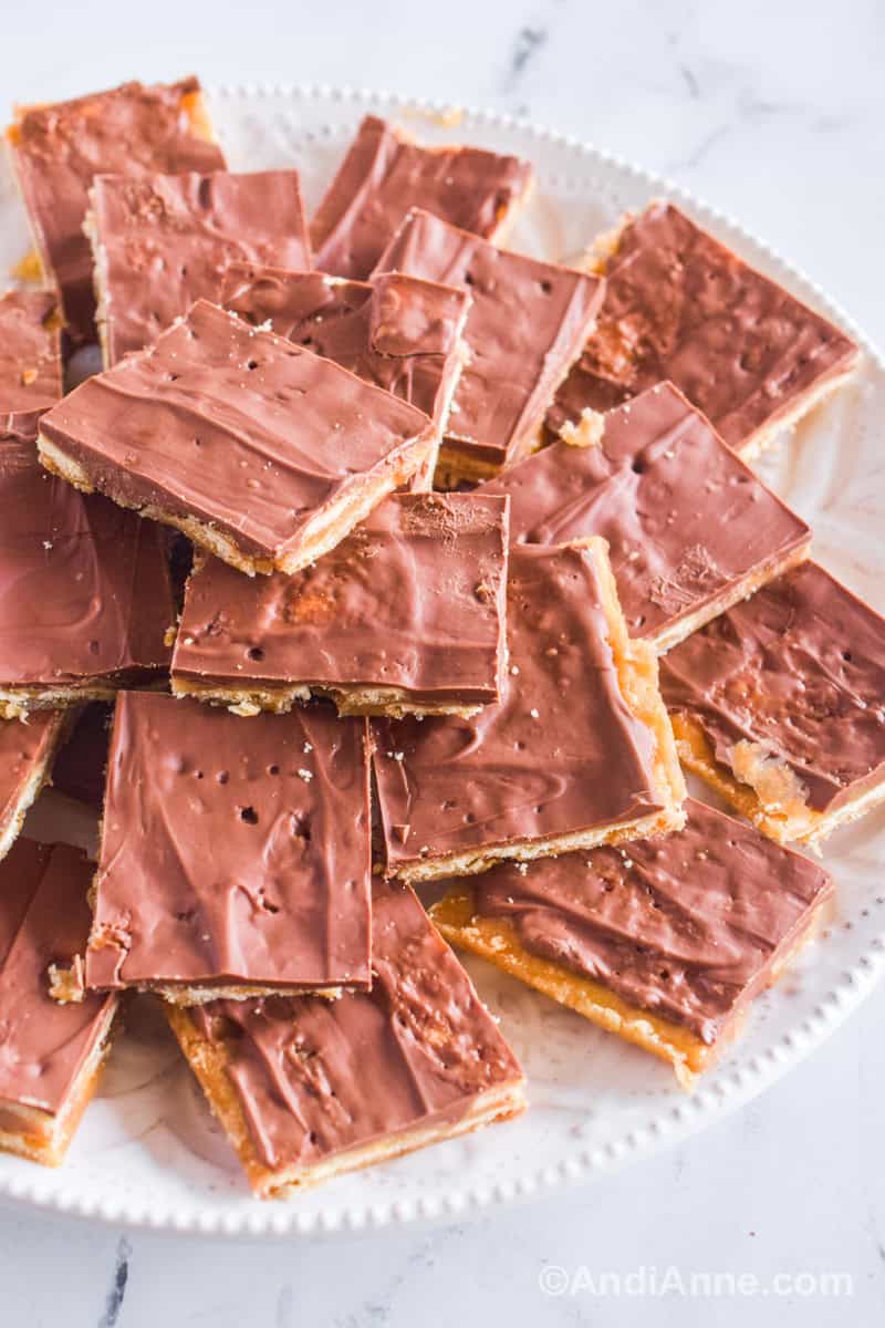 A stack of cracker candy squares piled on a white plate.