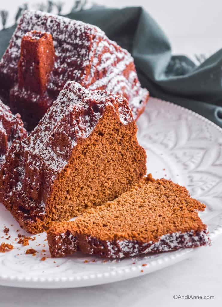 slice of gingerbread house cake on plate with rest of cake.
