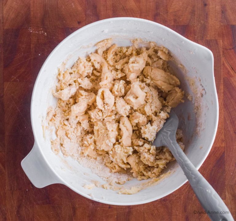 crumbly cookie dough batter in white bowl with spatula