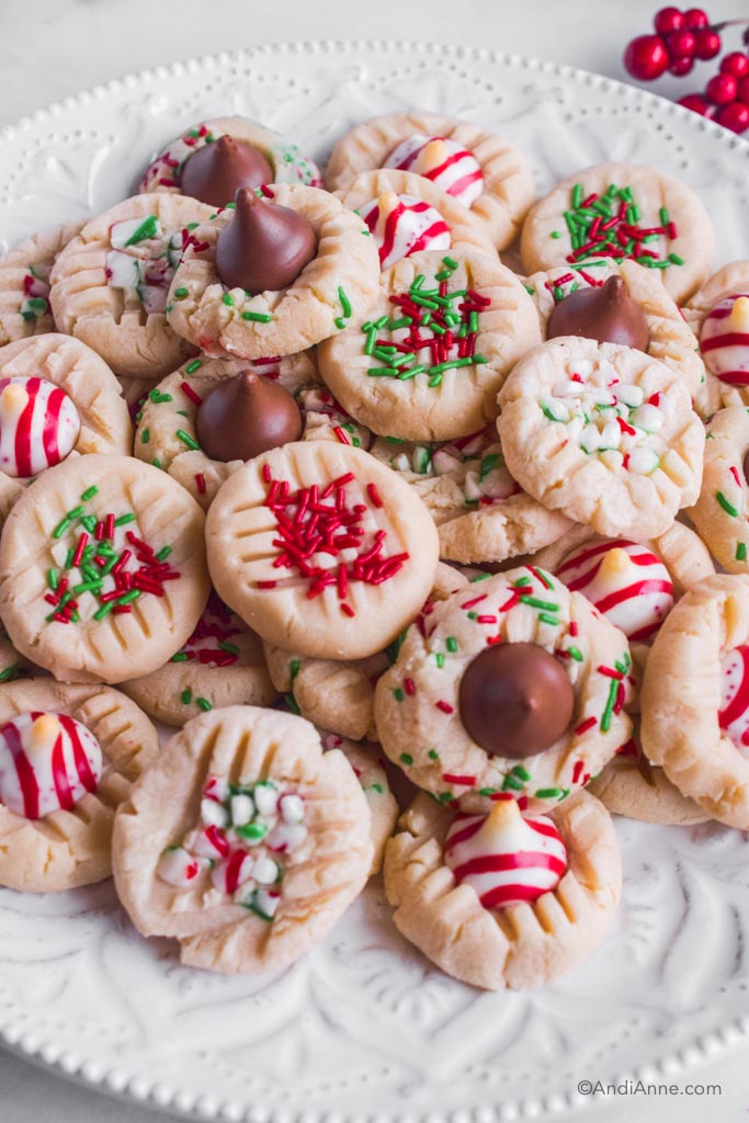 Christmas whipped shortbread cookies with sprinkles, crushed candy cane and hershey's kisses on top.