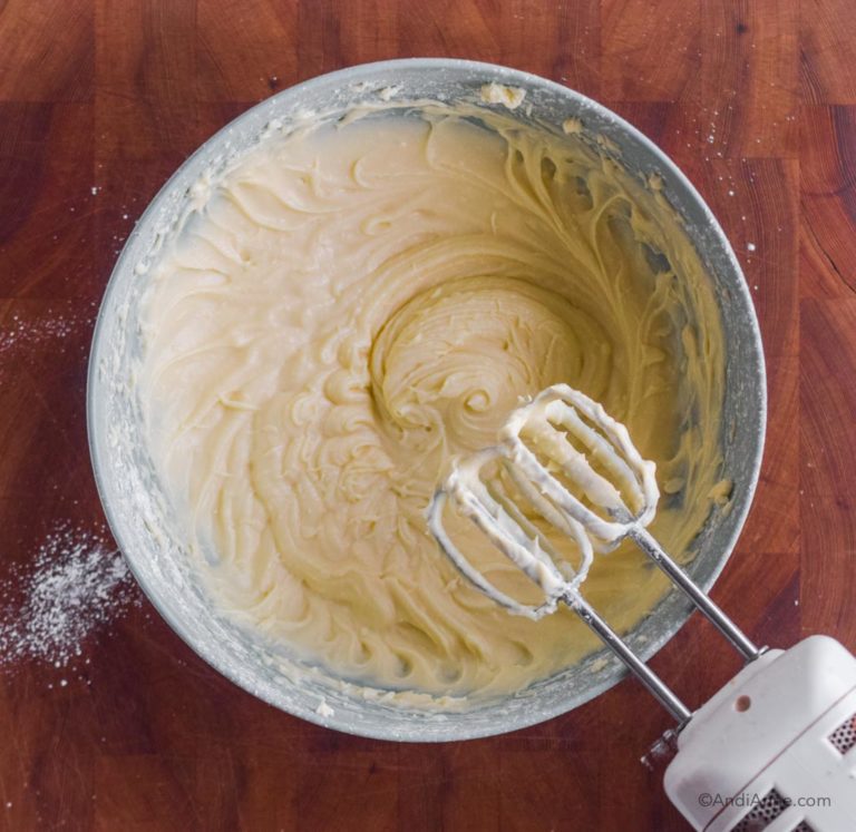 cream cheese frosting in bowl with hand mixer beside