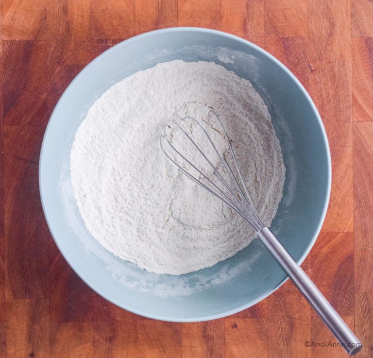 blue bowl of dry flour ingredients with steel whisk