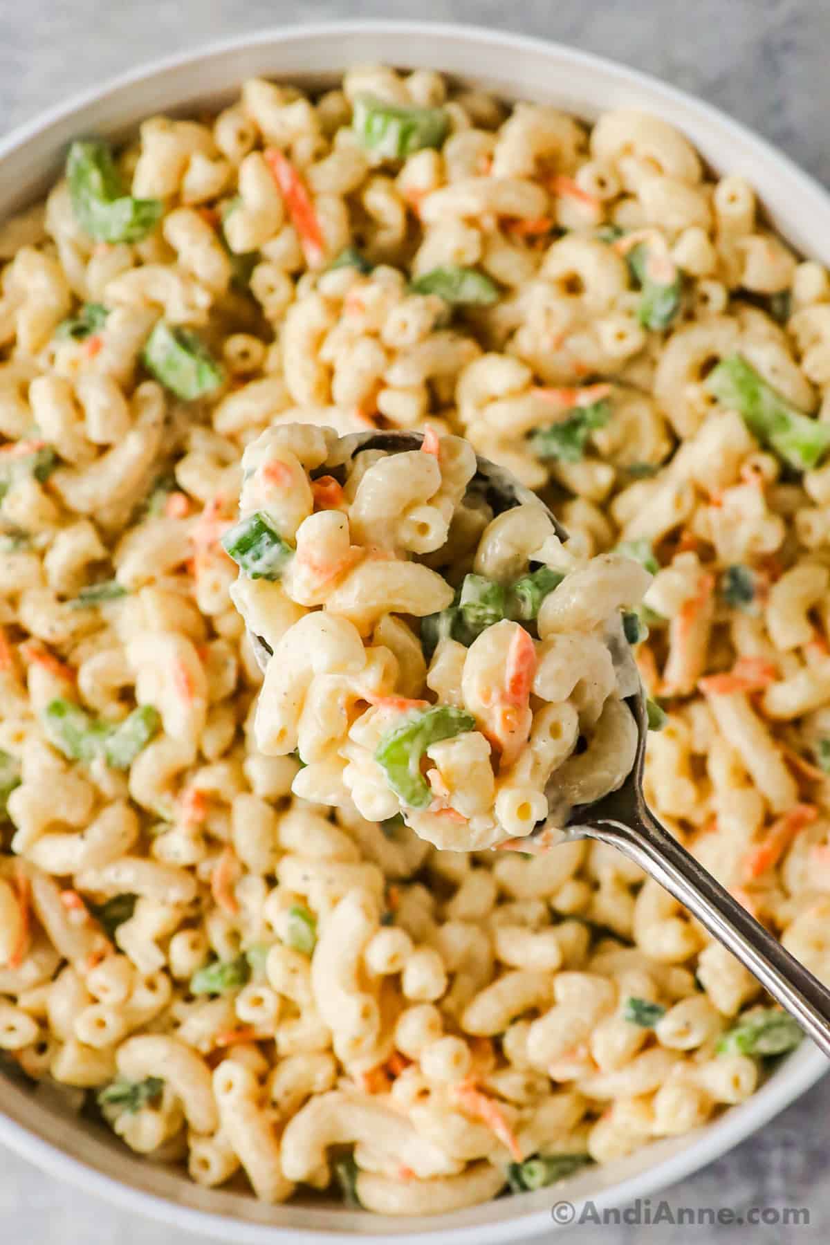close up of hawaiian macaroni salad in a steel bowl with spoon