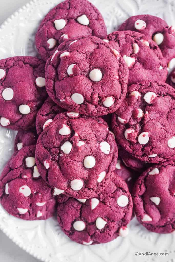 red velvet cake mix cookies with white chocolate chips stacked on a white plate.