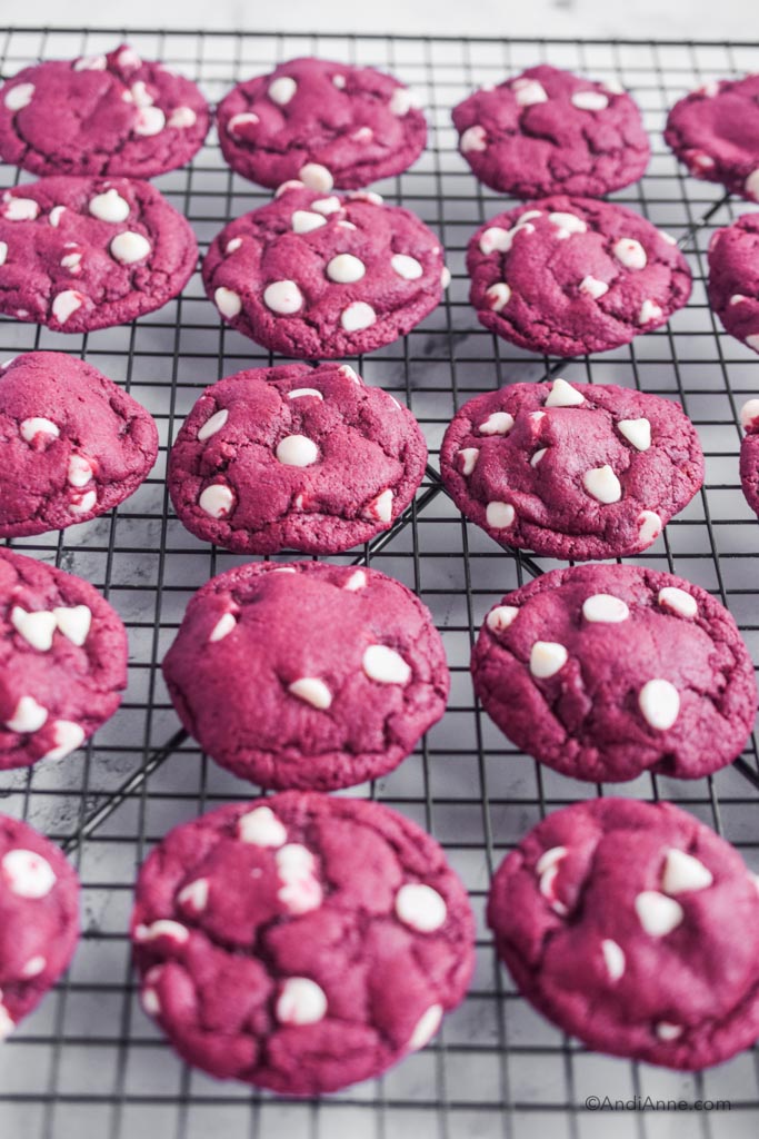 red velvet cake mix cookies with white chocolate chips on a black cooling rack.