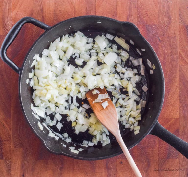 chopped onion cooked in skillet with wood spatula