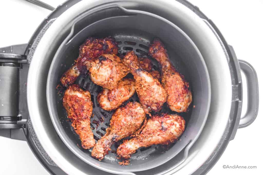 looking down into air fryer with crispy parmesan drumsticks