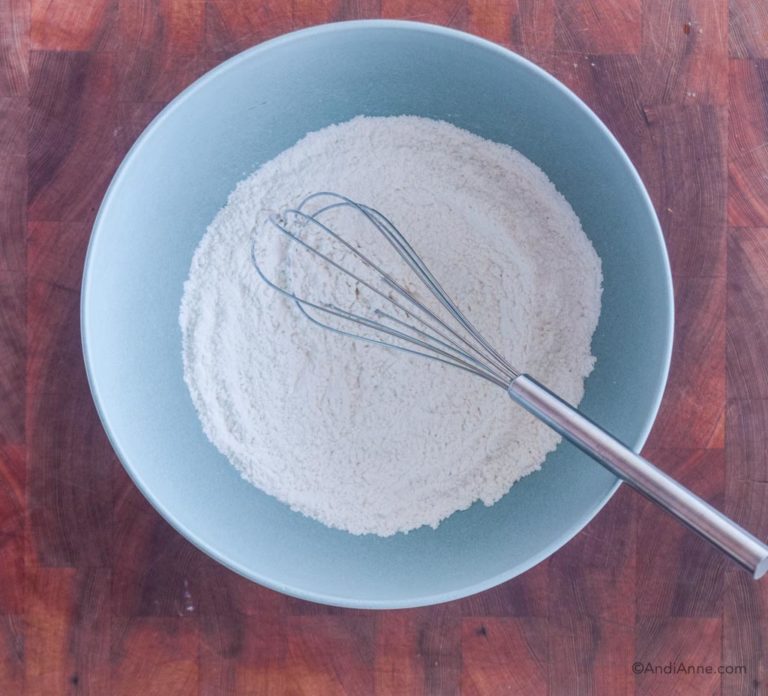 dry ingredients in a blue bowl with whisk