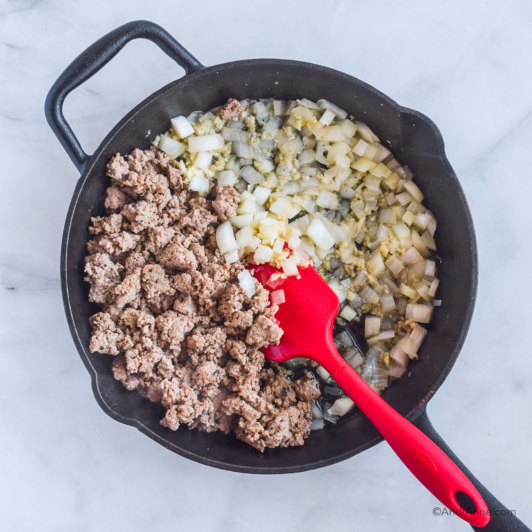 skillet with half ground turkey and half onion with red spatula