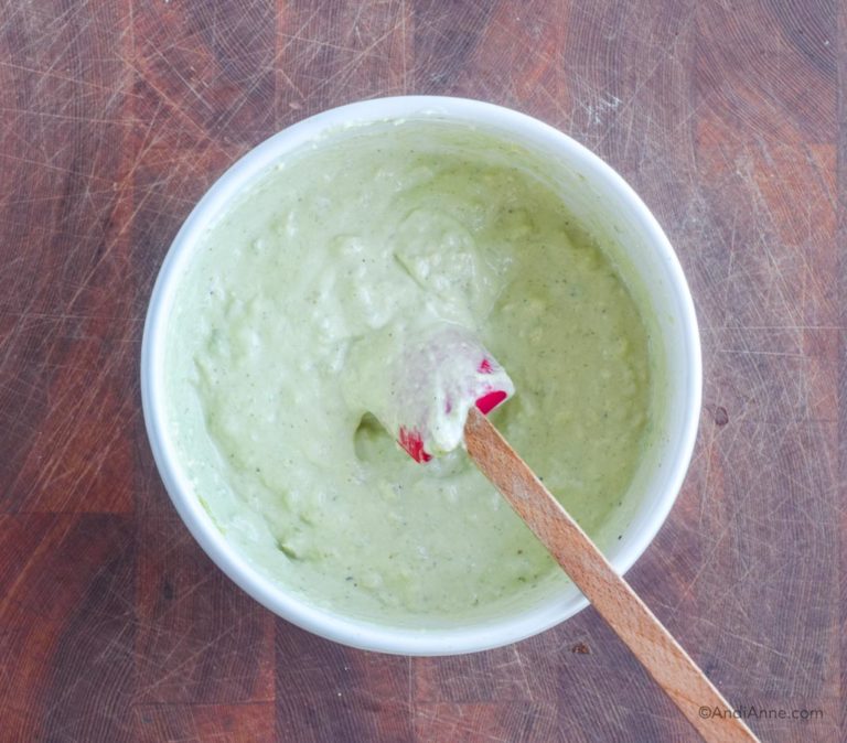 avocado salad dressing in white bowl with spatula