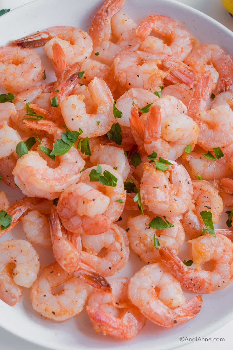 Close up of cooked shrimp on a white plate.