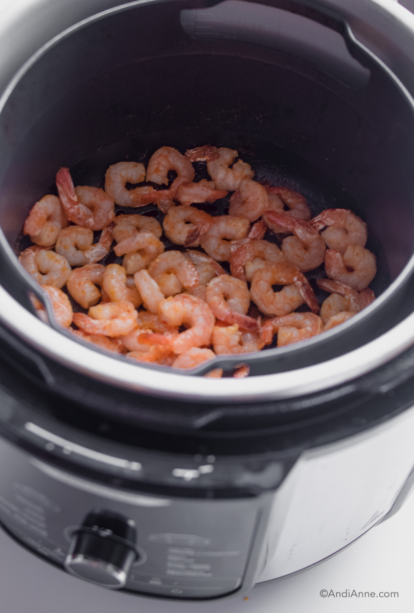 Looking into air fryer with cooked shrimp inside.