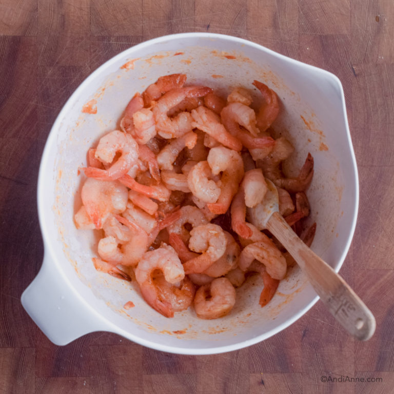 Shrimp in white bowl with small spatula.