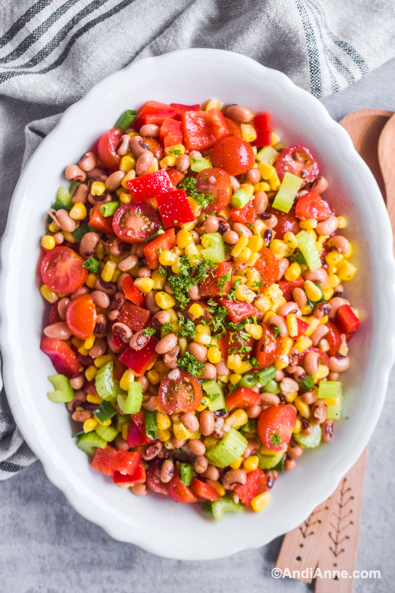Black eyed pea salad in a white scalloped bowl.