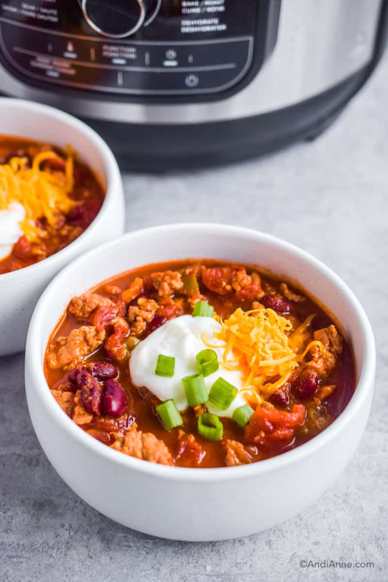 Two bowls of chili with instant pot in background.