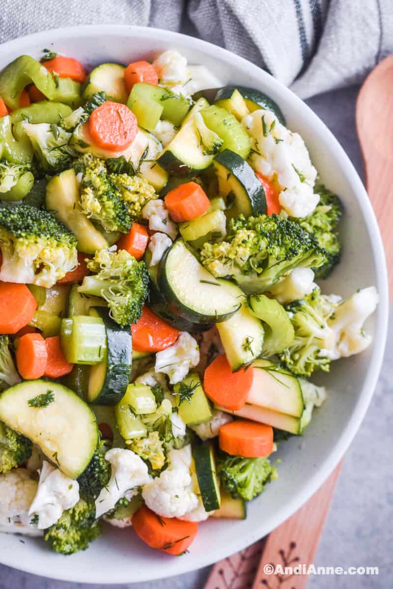 Close up of marinated vegetable salad in a white bowl.