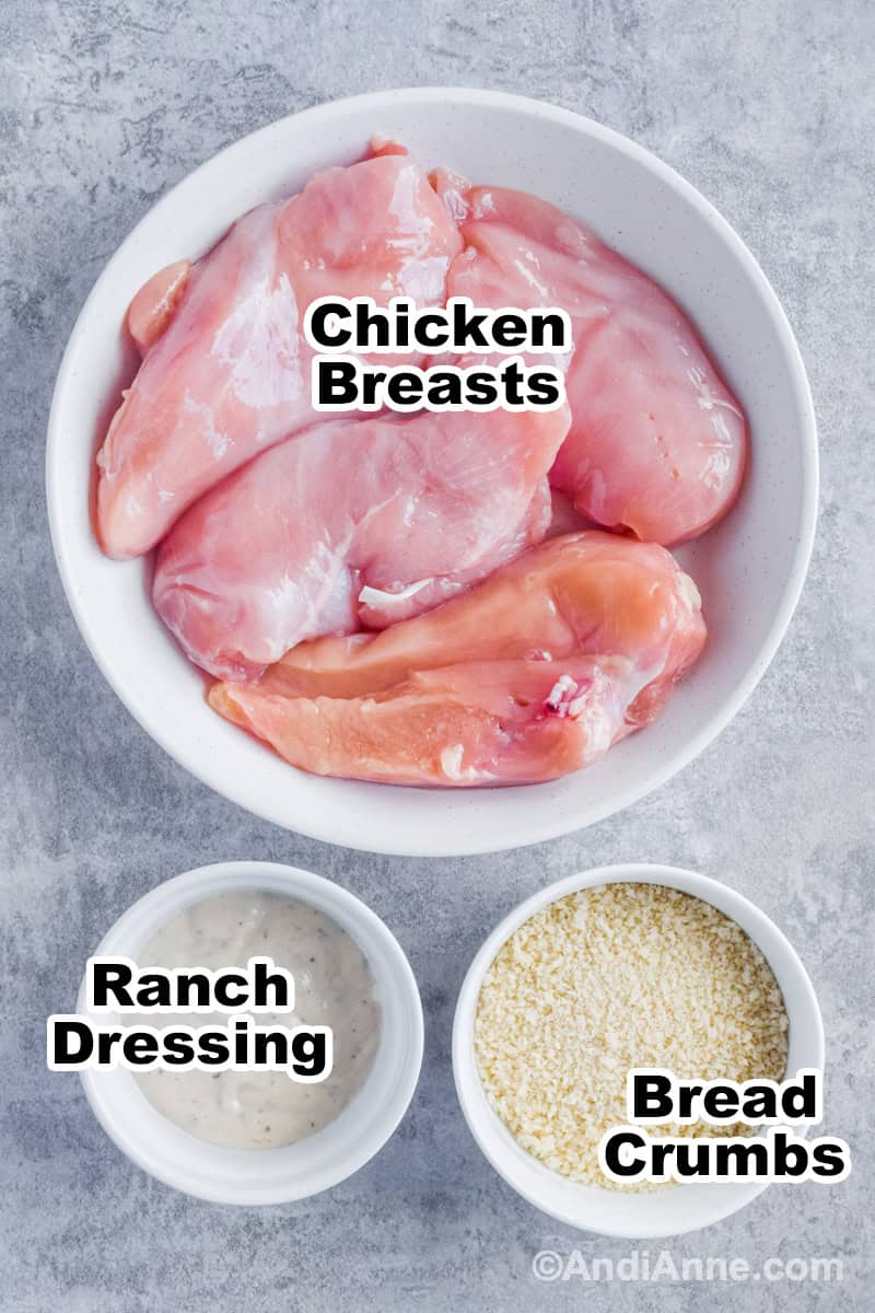 Bowl of raw chicken, bowl of ranch dressing, bowl of breadcrumbs.
