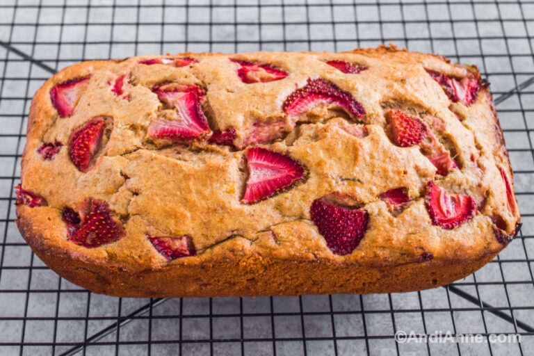 Uncut strawberry banana loaf on a cooling rack.