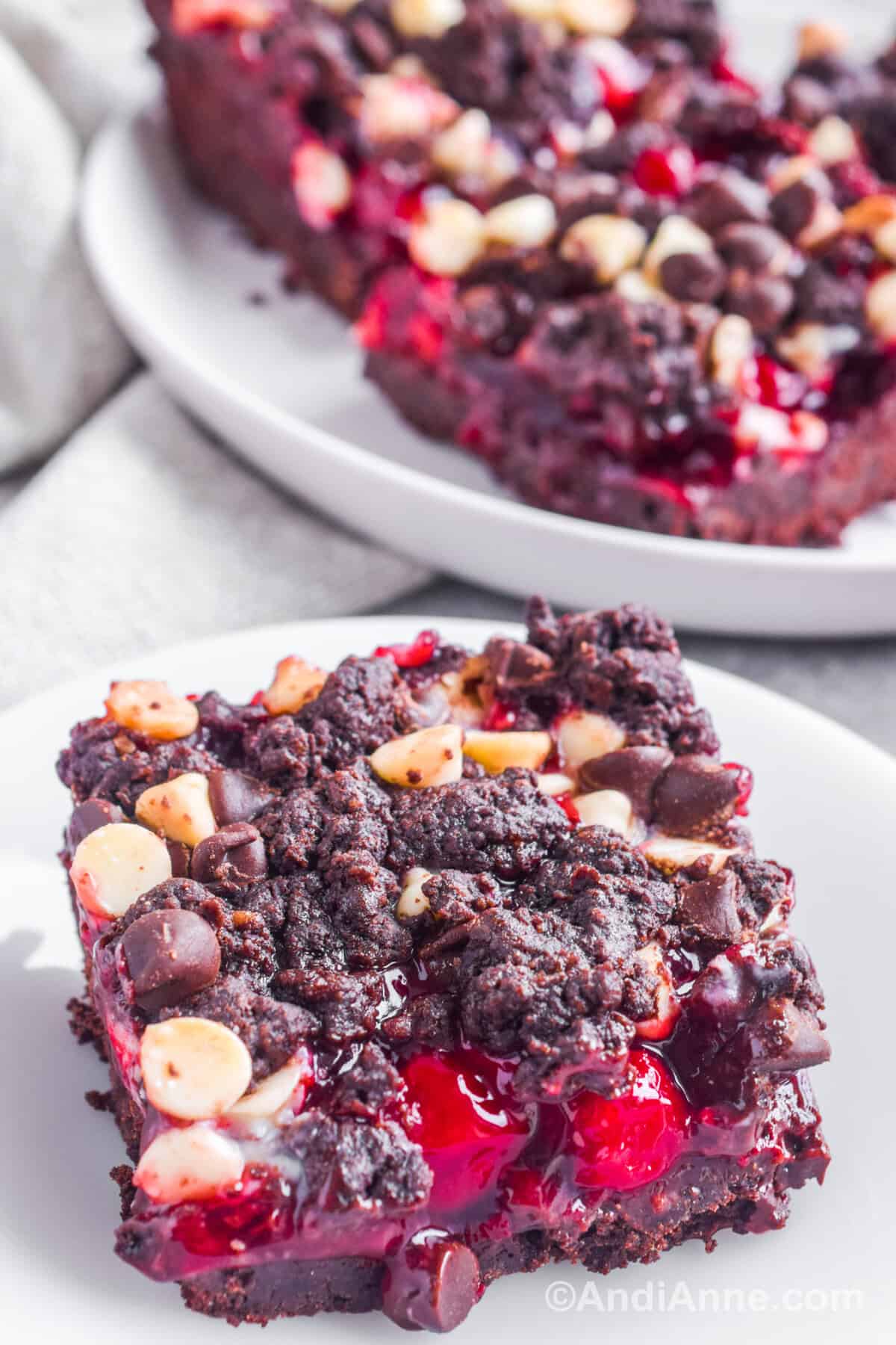 Close up of square of cookie bar with cherry filling on a plate.