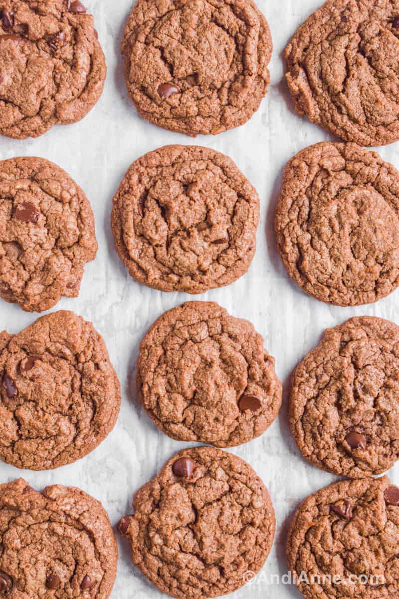Cookies beside one another on top of white parchment paper.
