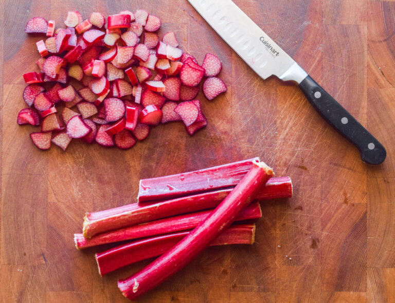chopped rhubarb and a knife on a cutting board.