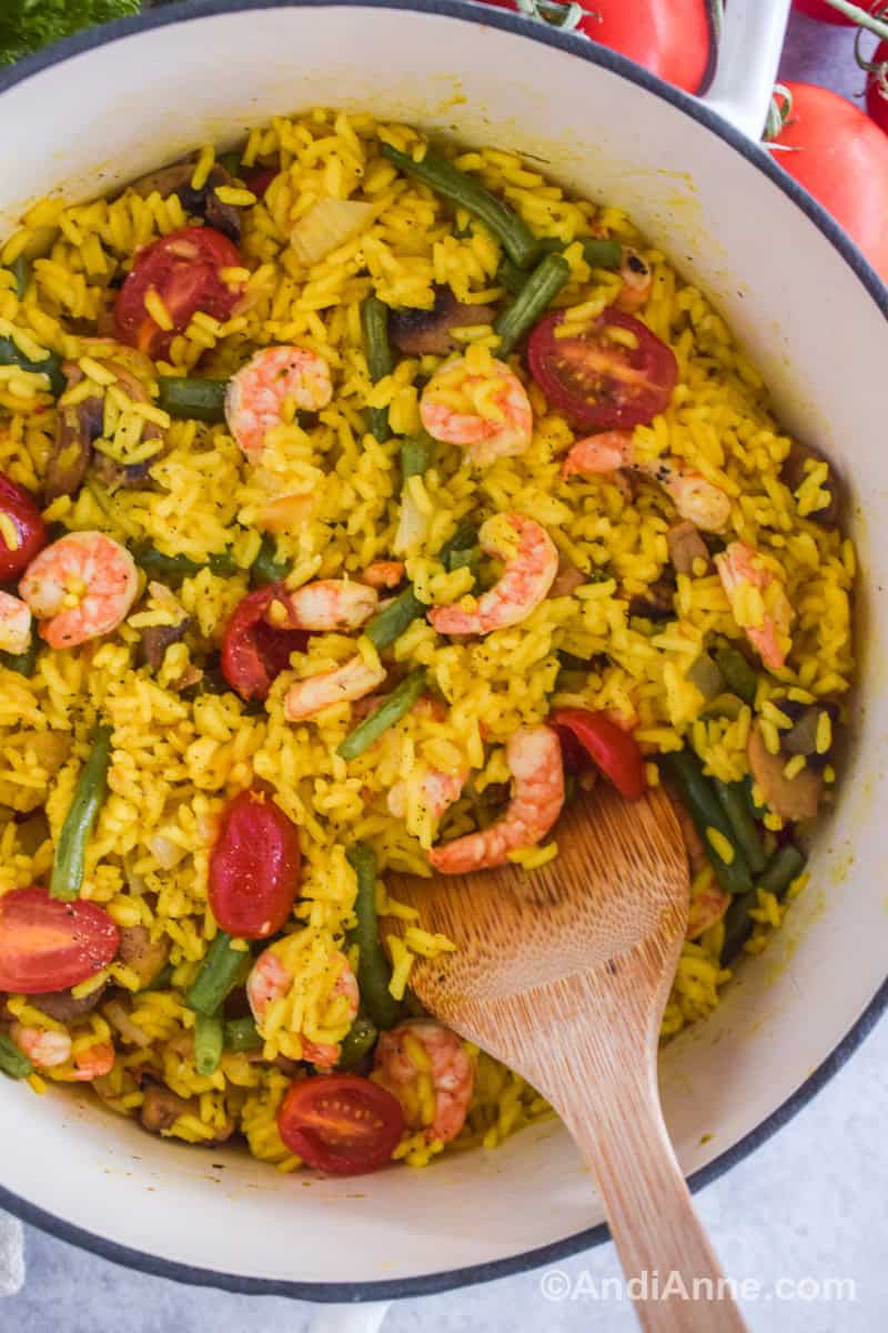 Close up of shrimp with turmeric rice recipe and sliced mushrooms, tomatoes and green beans.