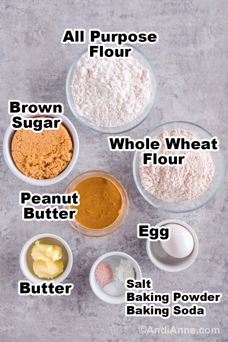 Recipe ingredients including bowls of whole wheat flour, all purpose flour, brown sugar, peanut butter, egg, butter, salt, baking powder, and baking soda.