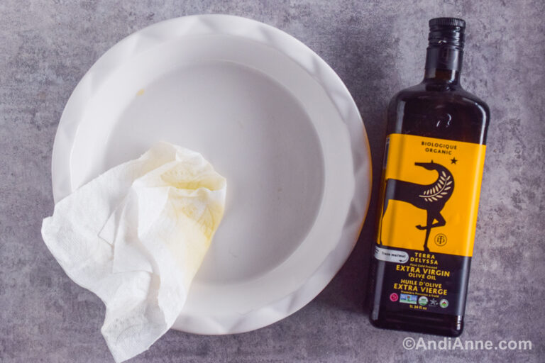 A pie plate, a paper towel and a bottle of olive oil.