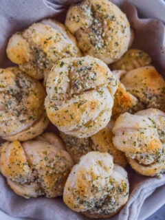 A pile of garlic parmesan knots in a bowl.