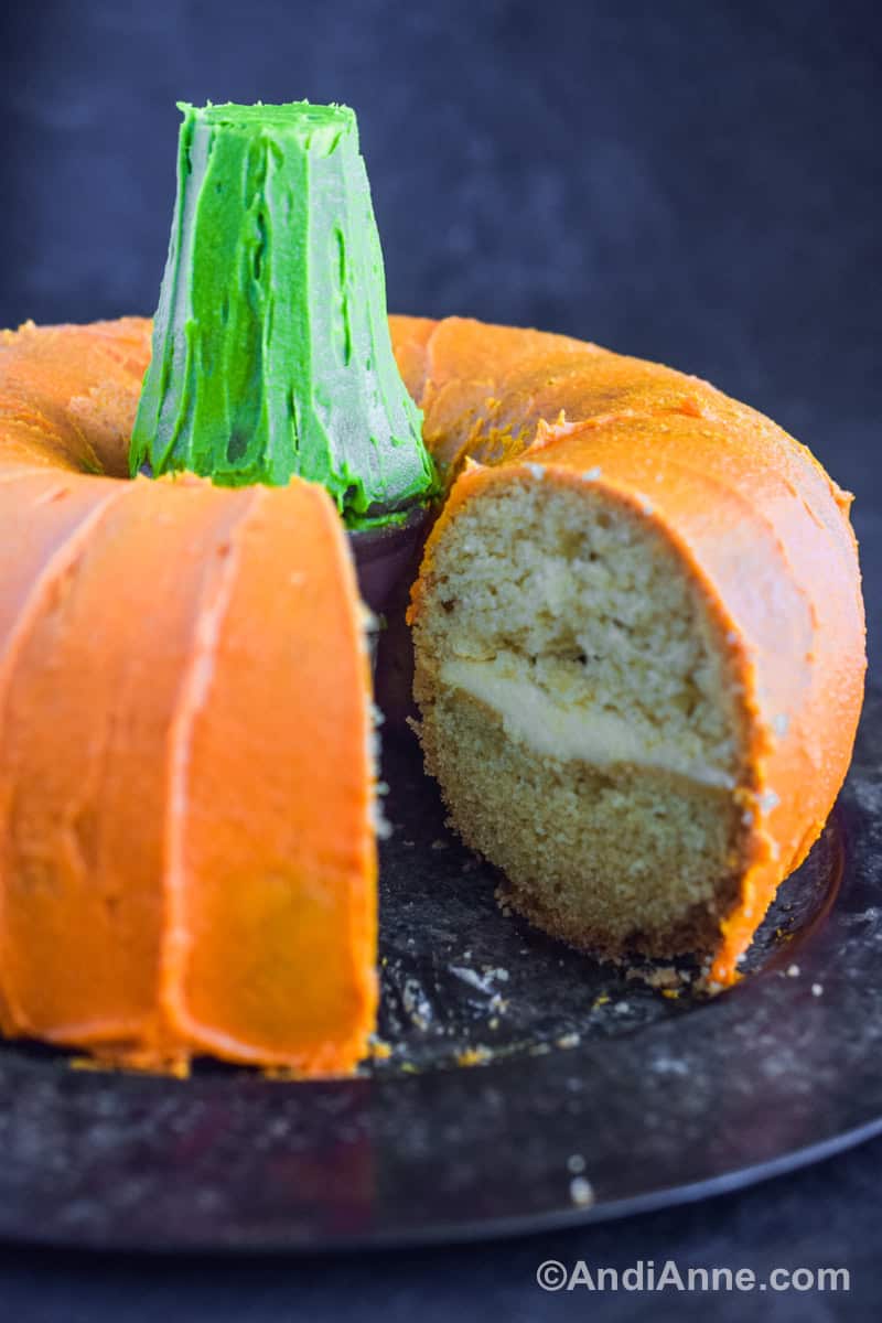A slice cut out of the pumpkin cake showing a white cake with a layer of frosting in the middle.