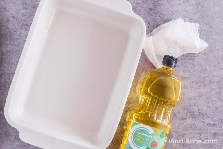 A rectangular baking dish, a paper towel and a container of vegetable oil.