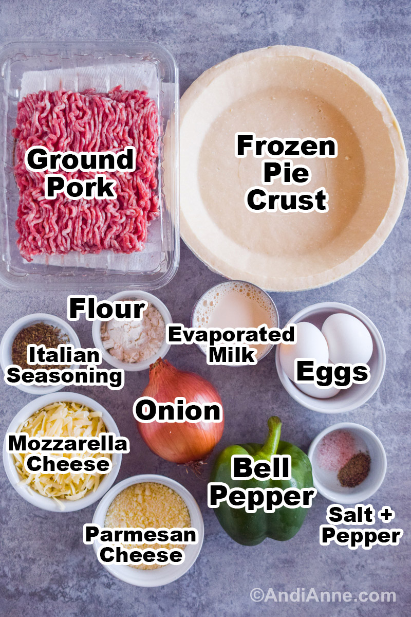 Recipe ingredients on the counter including raw ground pork, a frozen pie crush, bowls of cheese, spices, flour, eggs, can of evaporated milk, bell pepper and an onion.