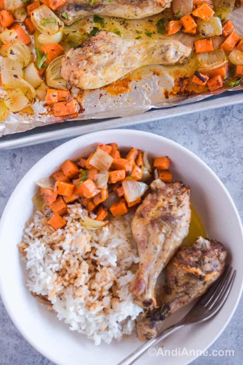 A white bowl with rice, chicken legs and chopped sweet potato and a fork.