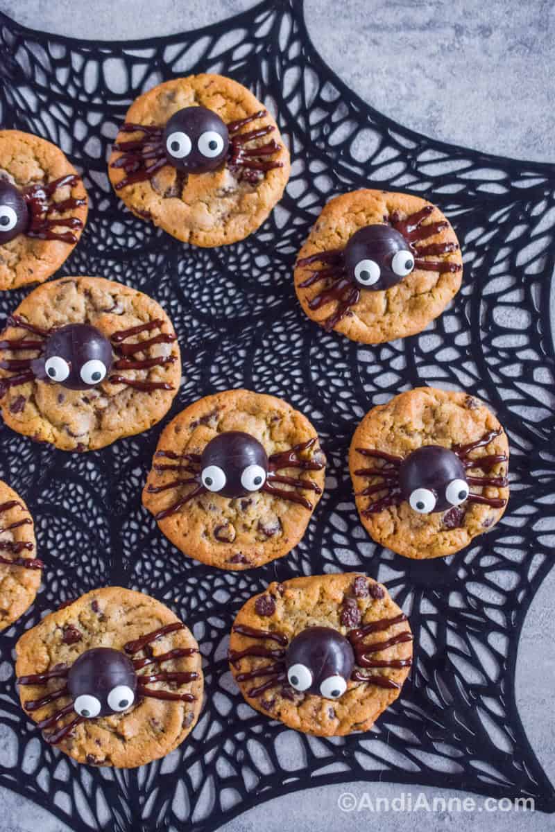 A black placemat with a web shape pattern and spider cookies placed on top.